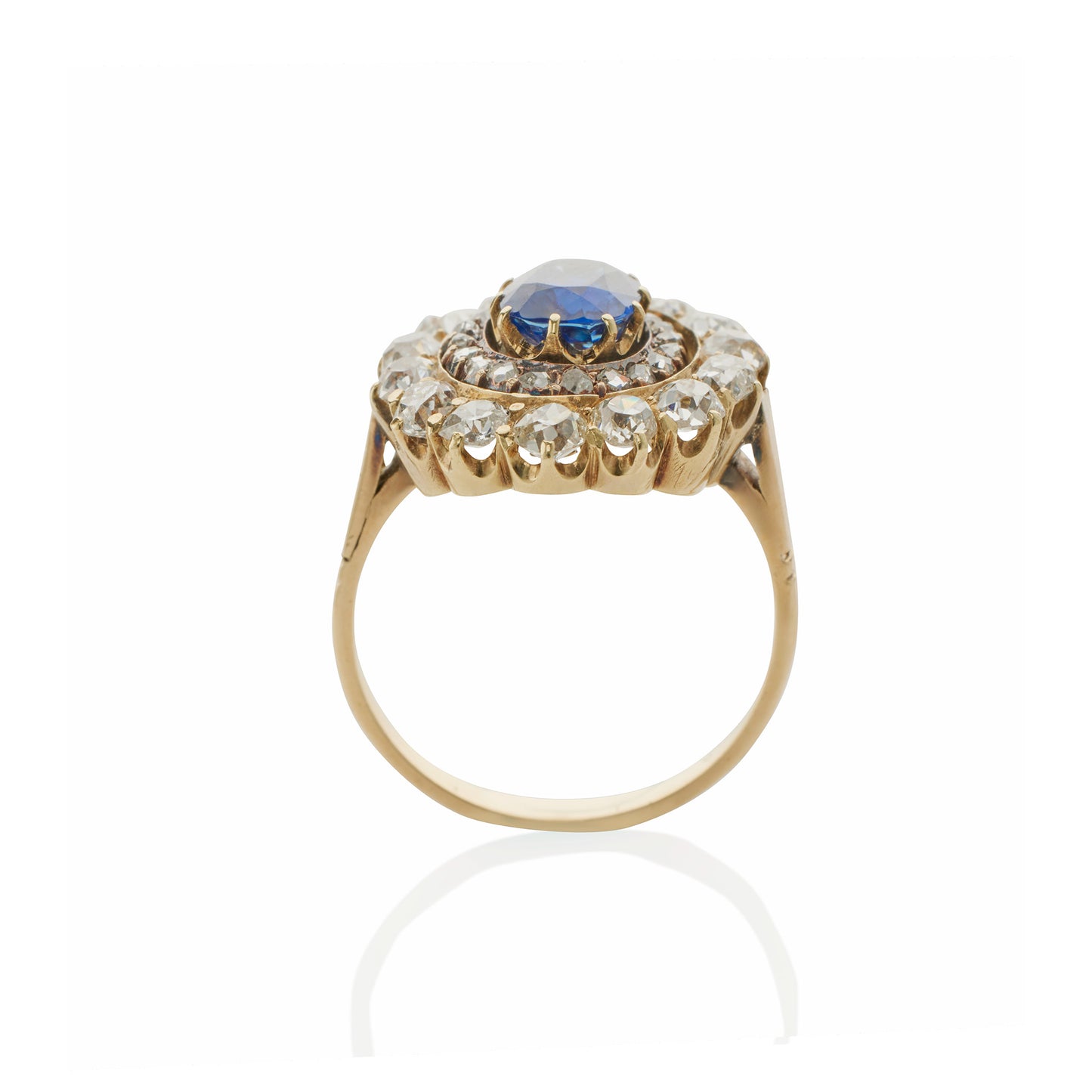 Macklowe Gallery An English Antique 15 karat gold/silver top ring with sapphire and diamonds. The ring centers on a no heat oval-cut sapphire with an approximate weight of .95 carat, 14 old mine-cut diamonds with an approximate total weight of 1.40 carats, and 19 rose-cut diamonds with an approximate total weight of .19 carat.  Designed in a classic oval cluster motif.